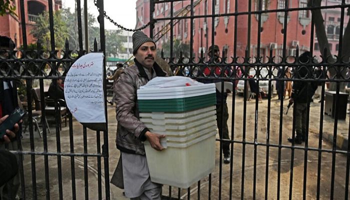 A man carries election-related material at a distribution centre in Lahore, Pakistan on February 7, 2024, one day before the opening of the polls || Photo: AFP