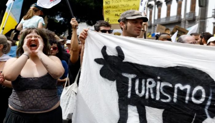 A Woman Shouts Next To A Banner With The Word “Tourism” During A Demonstration In The Canary Islands. Photo: Collected 