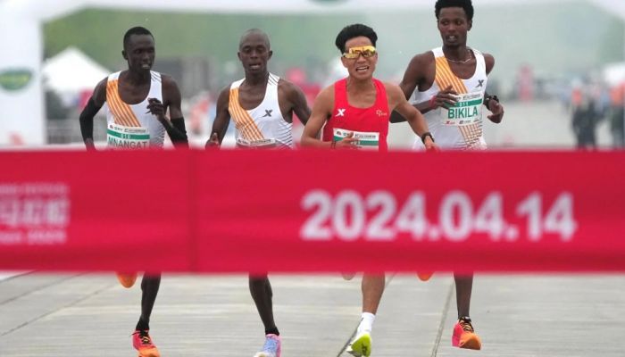 Chinese Runner He Jie, Ethiopian Dejene Hailu Bikila And Kenyans Robert Keter And Willy Mnangat At The Finish Line Of The Beijing Half Marathon On April 14, 2024. Photo: Reuters