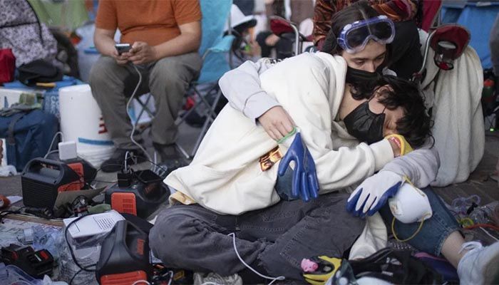 Pro-Palestinian demonstrators embrace while charging devices at an encampment on the UCLA campus Wednesday, May 1, 2024, in Los Angeles || AP Photo